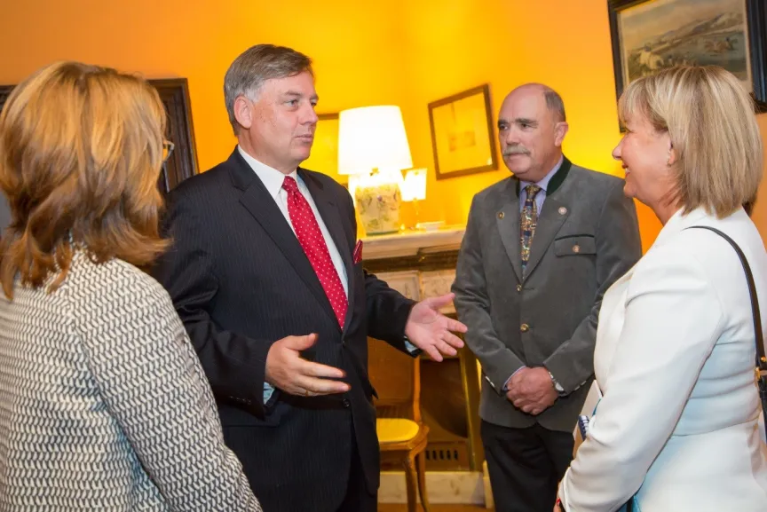 Mann spricht in einer Runde mit anderen Menschen