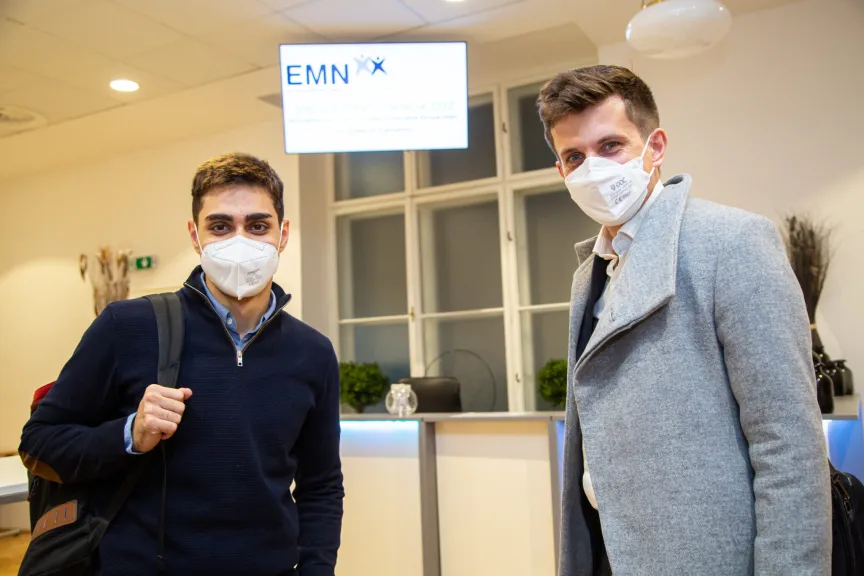 Zwei Männer mit Maske schauen in die Kamera