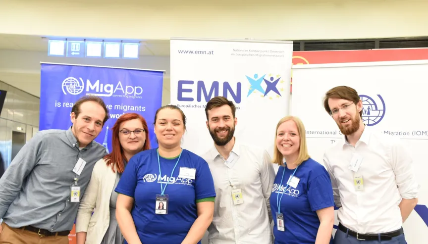 Gruppenfoto von sechs Personen, die in die Kamera lächeln