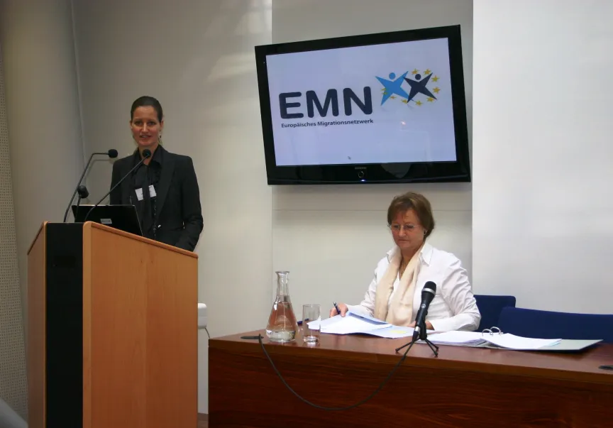 Vortrag mit Rednern und Rednerinnen sitzend an einem großem Tisch