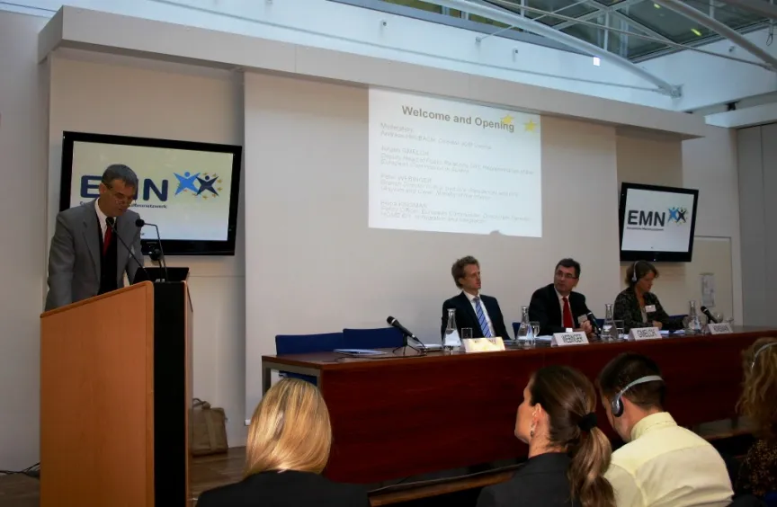 Vortrag mit Rednern und Rednerinnen sitzend an einem großem Tisch