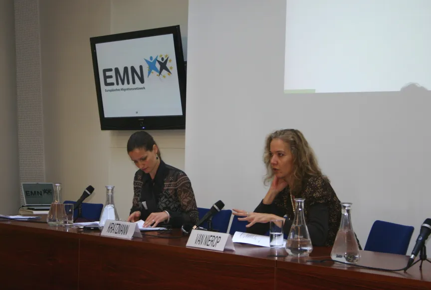 Vortrag mit Rednern und Rednerinnen sitzend an einem großem Tisch