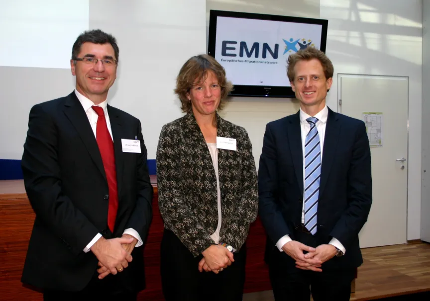 Gruppenfoto. Drei Personen lächeln in die Kamera