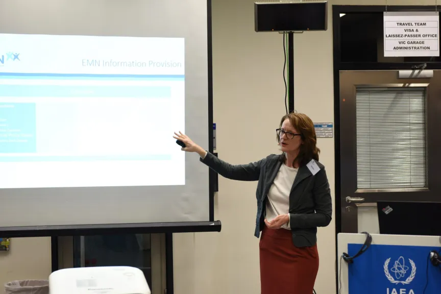 Frau hält einen Vortrag vor einer Leinwand