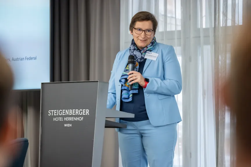 EMN-Conference- picture of Marian Benbow Pfisterer holding opening remarks on stage