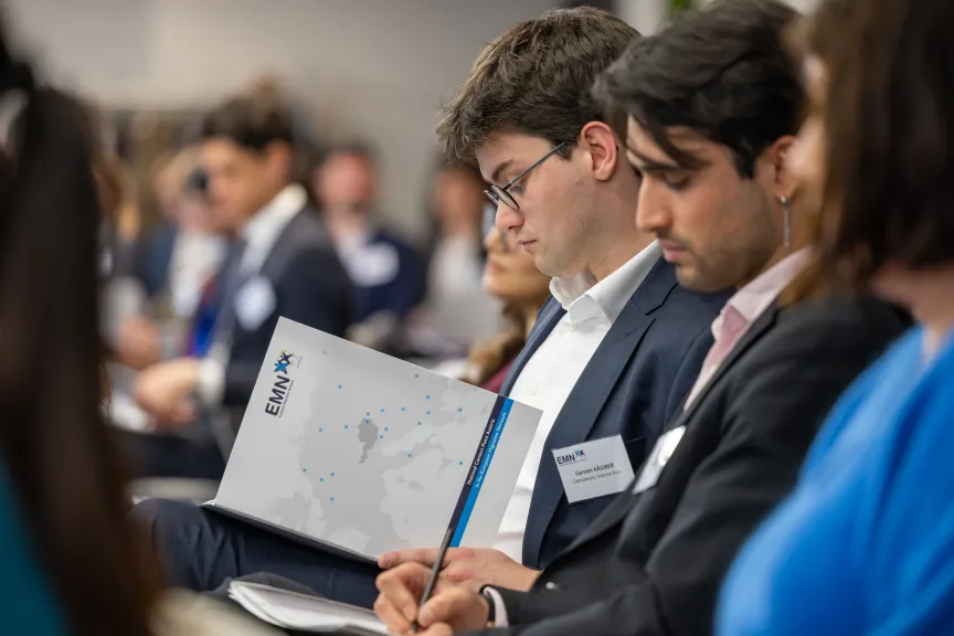 EMN-Conference 2025 - Picture of male audience member looking into emn folder